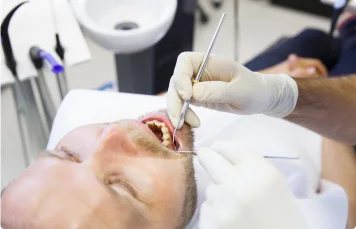 Dentist performing an oral exam on a patient.