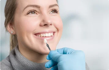 Dentist applying veneers to improve a patient's smile at Four Seasons Dental.